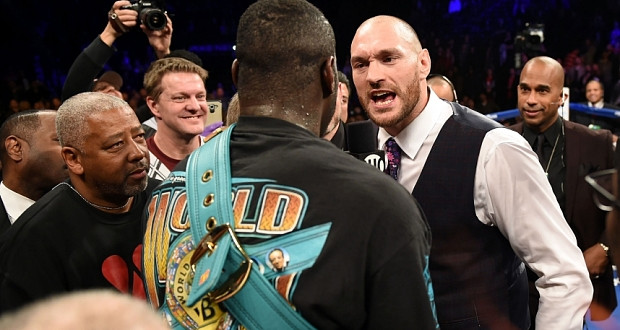 Tyson Fury of Britain (R) challeges Deontay Wilder of the US (C) after Wilder defeated Artur Szpilka of Poland in their WBC Heavyweight Championship bout at Barclay's Center in Brooklyn, New York, on January 16, 2016.  Wilder knocked out Szpilka in the ninth round.  